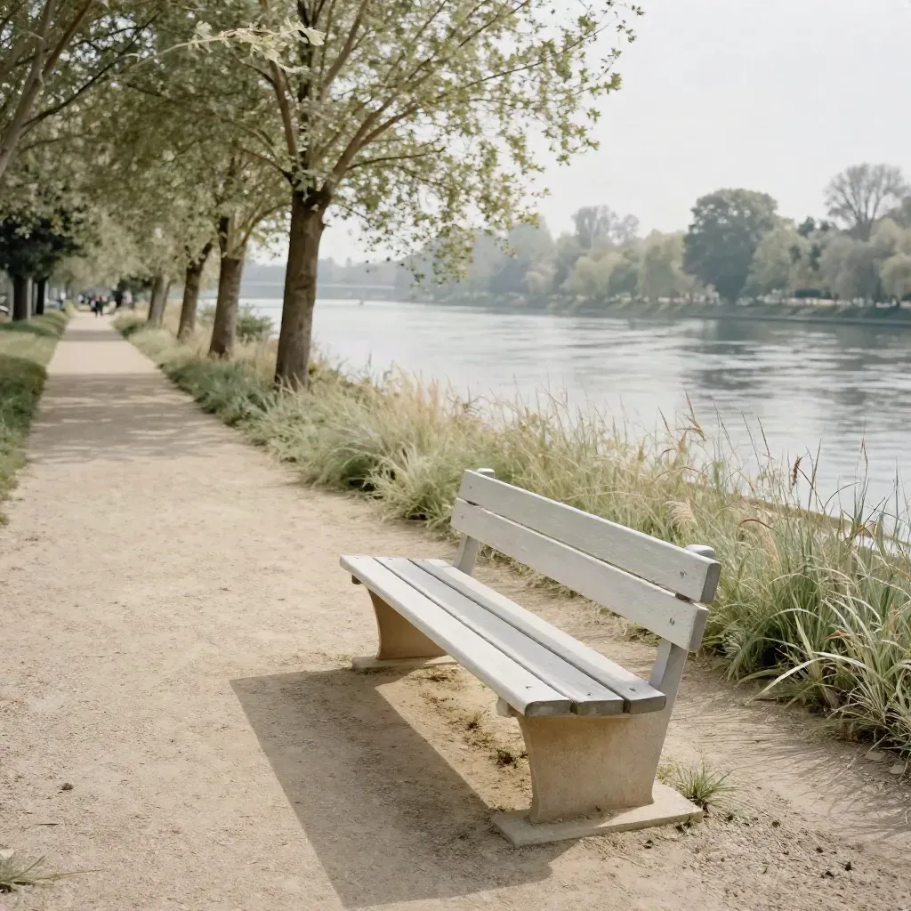 Sentier plat au bord de la Seine avec banc vide, peupliers et herbes qui frémissent.